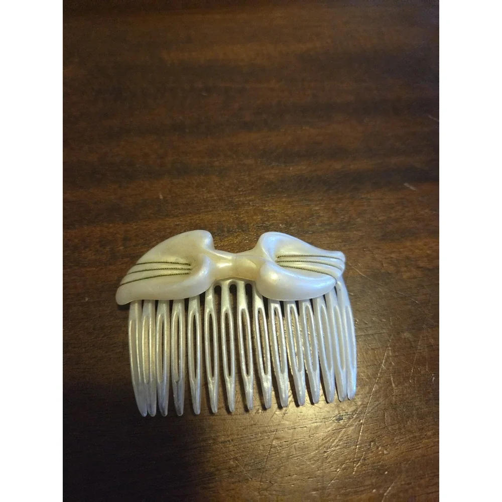 T.Z. Inc. 1981 vintage hair comb is made of faux mother-of-pearl cellulose...